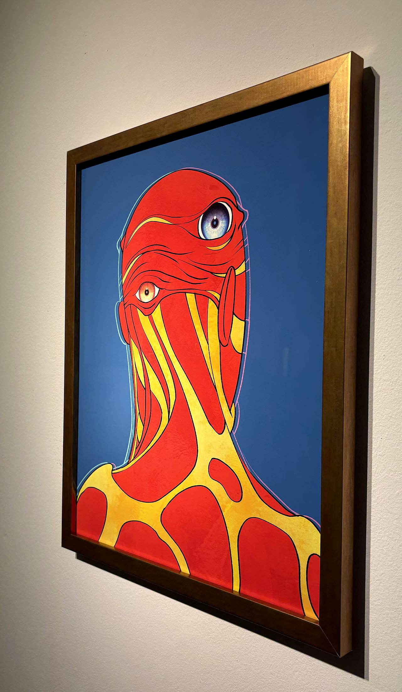 The gold frame from the side, on a white gallery wall.